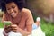 Our connections with nature is the best medicine. a young man texting while relaxing at the park.