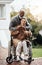 Our love remains strong. an elderly man pushing his wheelchair-bound wife around the yard at home.