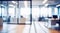 out of focus background image of a light modern office interior with see-through glass panels and windows and bright lighting
