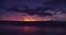 Out of focus background plate of deep purple and orange sunset on the beach