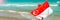 Out of focus. Blurred photo. Singapore flag waving on wind on ocean waves background. Young woman in red dress holds Flag of
