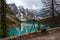 A out-of-focus camera in the foreground and Emerald lake in the background.