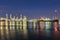 Out of focus, Oil refinery at twilight with river reflection