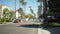 Out of focus shot of residential street lined with palm trees swaying in wind