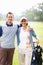 Out for a game. Portrait of golfing couple standing with arms around and smiling.