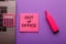 Out of office - message on pink sticky note on work table