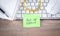 Out of office message on sticky note with computer keyboard, mouse, notepad