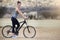 Out for a wild bike ride. Portrait of a young woman on a bicycle looking at a group of rhinos in the veld.