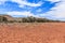 Outback landscape with blue sky and scattered clouds in South Australia with flat ground with gravel and rocks