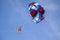 Outdoor activities, skydiving, Skydiver flying with a colorful parachute by speed boat on sea