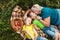 Outdoor activity. Child boys with theirs grandma eat just picking apples and lie on a plaid. Brothers holding fresh