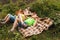 Outdoor activity. Young child boys eat just picking apples and lie on a plaid blanket. Brothers holding fresh organic