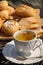 Outdoor afternoon tea, served in white porcelain cup, spoon, cheese, ham and bread board, top view