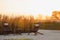 Outdoor al fresco chairs and table on a wooden deck at sunset in the spring with grape vines and hills in the background, Napa