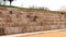 Outdoor amphitheater with large limestone blocks arranged in long rows, designed for seating in a public space, on a sunny