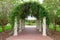 Outdoor archway with columns and vines on lattice