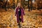 Outdoor autumn portrait of happy smiling plus size red hair woman in coat walking in fall park.