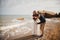 Outdoor beach wedding ceremony near the sea, stylish happy smiling groom and bride are having fun and laughing