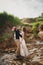 Outdoor beach wedding ceremony, stylish happy smiling groom and bride are kissing near small river. The moment before kiss