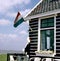 Outdoor cafe with empty chairs and Dutch National Flag