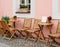 Outdoor cafe empty tables along a Prague cobblestone street.