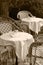 Outdoor cafe and restaurant with tables, chairs and glasses waiting for customers to arrive in black and white sepia tone