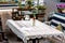 Outdoor cafe table with a knitted tablecloth and a glass bottle.