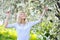 Outdoor casual portrait of young smiling lady in blooming tree