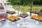 Outdoor catering banquet in summer. Table with snacks, canapes and fruits at a summer banquet in the background of nature.