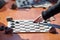 Outdoor checkers tournament on paper checkerboard on table, close up players hands