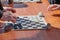 Outdoor checkers tournament on paper checkerboard on table, close up players hands