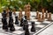 Outdoor chessboard with black and yellow figures with unfocused background. Competition and strategy concept. Intelligent sport.