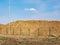 Outdoor construction earthworks with a large pile of sand behind the fence and a heavenly landscape