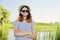 Outdoor country portrait of teenage girl in hat sunglasses near pond in the reeds