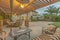 Outdoor dining area under a wooden pergola on the patio of a house