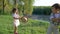 Outdoor entertainment for children, little boy and child girl play with straw hats in hands near lake