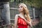 Outdoor fashion beautiful young woman photo near old HOMESTEAD summer. Portrait girl blondes in red dress.