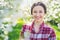 Outdoor fashion photo of beautiful young smiling woman surrounded by spring blooming cherry flowers.  Pretty tenderness model look