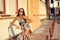 Outdoor fashion portrait of a beautiful brunette with bike