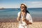 Outdoor fashion portrait of handsome stylish tourist man posing at the beach