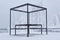 Outdoor furniture - picnic table with swing benches - in a frosty winter park