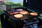 Outdoor grill with hamburgers, brats, and hot dogs