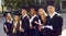 Outdoor group portrait of happy diverse college or university graduates with diplomas