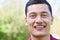 Outdoor Head And Shoulders Portrait Of Smiling Young Man