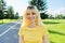 Outdoor headshot portrait of positive teenage blonde looking at the camera.