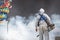 Outdoor healthcare worker using fogging machine spraying chemical to eliminate mosquitoes at Chinese shrine