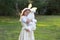 Outdoor horizontal portrait of little Caucasian girl in festive dress hugs big white plush bunny toy