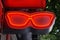 Outdoor illuminated advertising sign in the shape of red glasses close-up