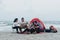 Outdoor independent travel concept, a group of four Asian men and women camping and having fun partying by the sea