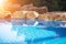 Outdoor inground residential swimming pool in backyard with hot tub. Sun flare